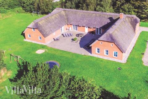 Områdets typiske klitgård-stil kommer tydelig frem i dette store luksushuset, som ligger nær Nordsjøen og har plass til 24 personer\r\n