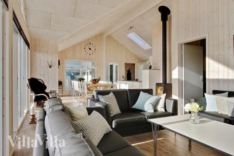 Det er god plass til at 16 personer sitter sammen i feriehusets oppholdsrom under et besøk i luksushus 345 i Fyn og øyer.