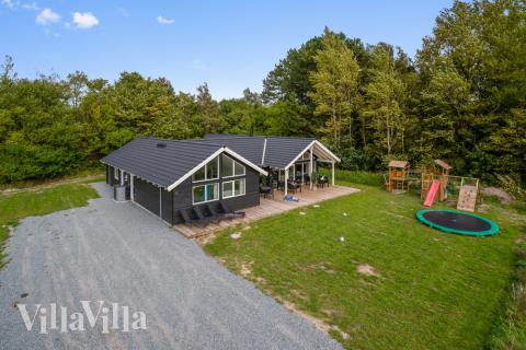 I det attraktive feriehuset nr. 416 i Nordsjælland finnes det mengder av utendørsaktiviteter, som leketårn og huskestativ.