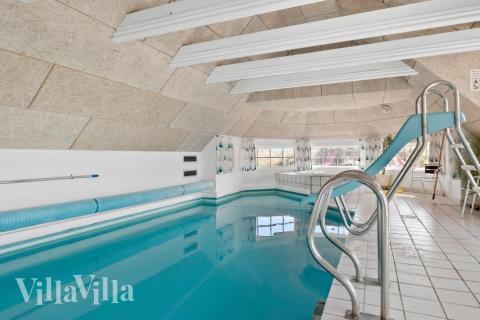 Feriehus 675 har et flott basseng med sklie, et stort innebygd boblebad og en badstue