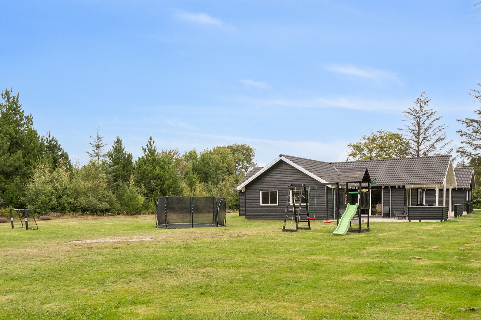 I det attraktive feriehuset nr. 387 i Vestjylland finnes det mengder av utendørsaktiviteter, som leketårn og huskestativ.