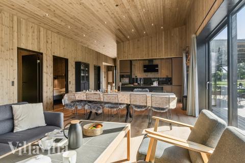 Det er god plass til at 12 personer sitter sammen i feriehusets oppholdsrom under et besøk i luksushus 925 i Limfjorden.