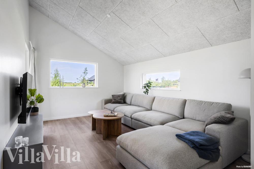 Sofaen i luksushus nr. 942 i Fyn og øyer er perfekt for å hygge seg med et brettspill eller se en film sammen.