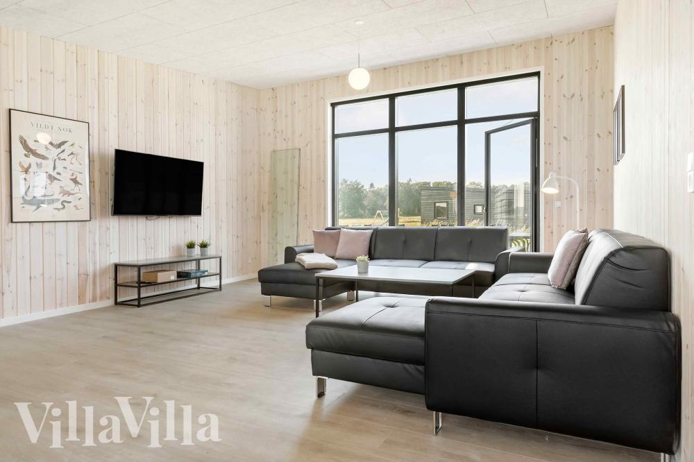 Sofaen i luksushus nr. 1014 i Østjylland er perfekt for å hygge seg med et brettspill eller se en film sammen.